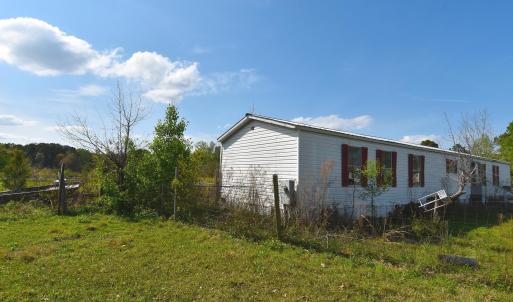 View of side of home featuring fence and a yard