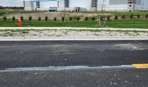 Road dividing Amazon Fullfillment Center and subject property
