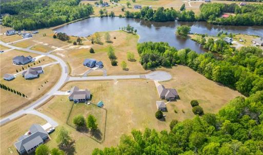 Aerial view of the 1.3 acre lot and surrounding countryside. The lot is raised, with water views towards the pond.