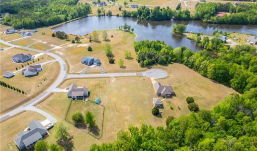 Aerial view of the 1.3 acre lot and surrounding countryside. The lot is raised, with water views towards the pond.