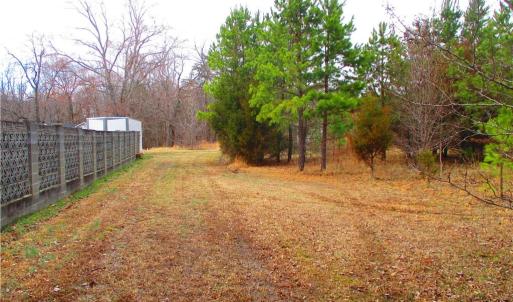 Asphalt drive ends and becomes a field.
