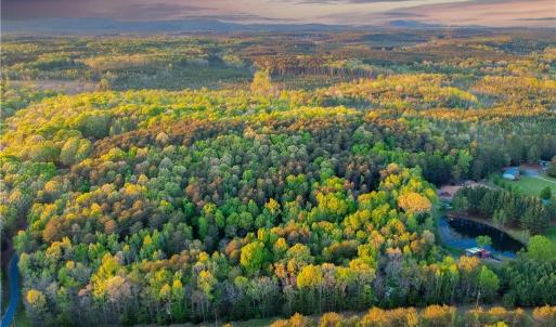 Property is approximately located in between driveway on the left and pond on the right. Photo color virtually enhanced.
