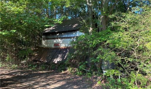 Old abandoned cabin site provides a pre-existing footprint and potential starting point for a replacement build.