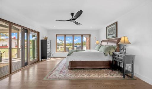 Primary bedroom w/ ceiling fan and direct access to the screen porch