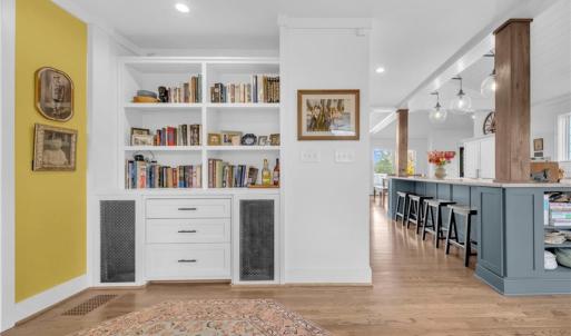 Sitting room adjacent to foyer w/ built in display shelves/bookcase and cabinet storage