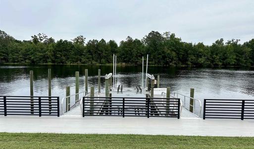 View of dock featuring a water view and a yard