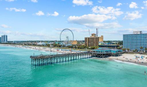 Drone / aerial view with a water view and a beach