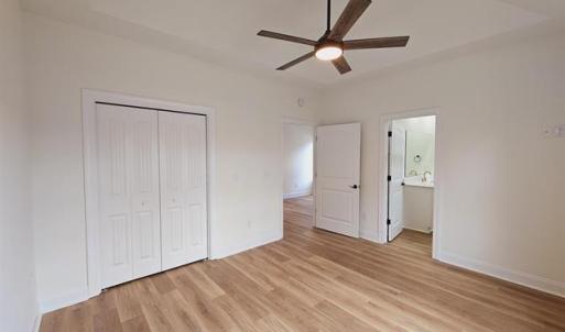 Unfurnished bedroom with ceiling fan, a closet, li