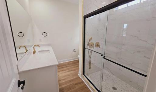 Bathroom featuring toilet, a marble finish shower,