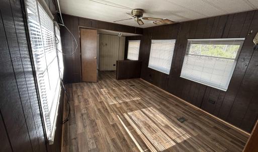 Empty room featuring dark wood-style floors, ceili