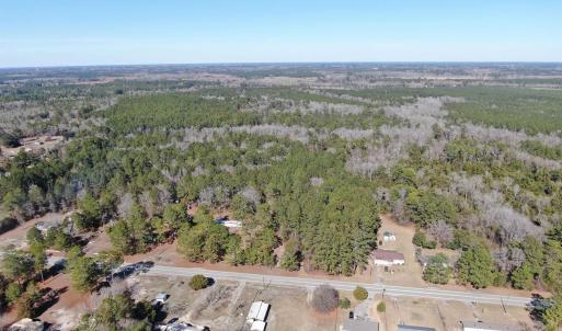 Birds eye view of property with a wooded view
