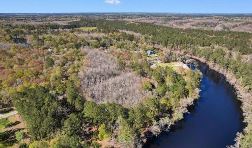 Bird's eye view with a water view and a view of tr