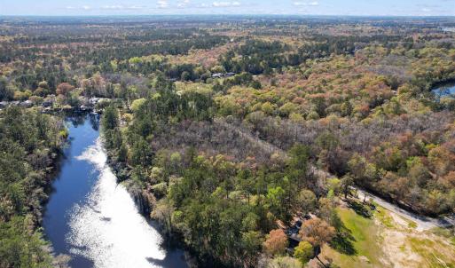 Aerial view featuring a water view and a forest vi