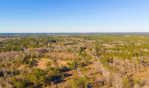 Birds eye view of property with a wooded view
