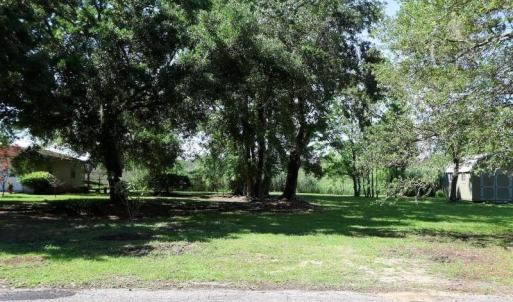 View of grassy yard featuring a storage unit and a