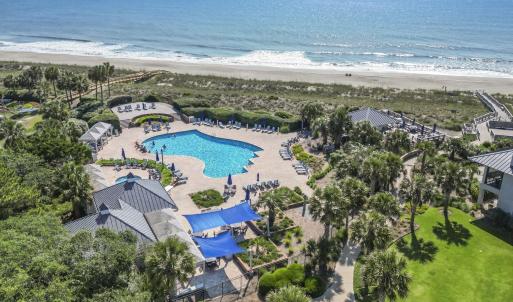 Aerial view of waterfront with a beach and a pool