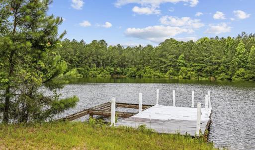 Dock featuring a water view and a view of trees