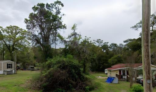 View of green lawn featuring a wooden deck