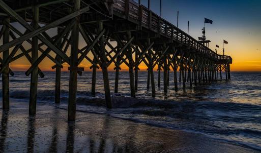 View of community featuring a pier and a water vie