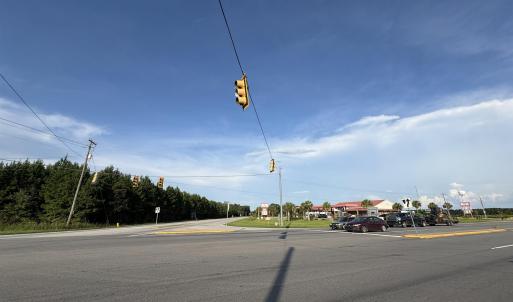 View of asphalt street with traffic lights and tra