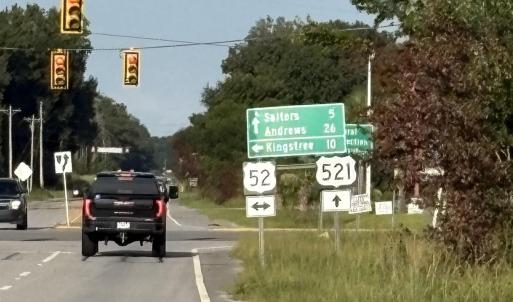 View of asphalt street with traffic signs and traf