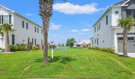 View of grassy yard with an attached garage and dr