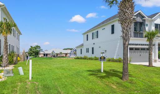 View of green lawn featuring an attached garage an