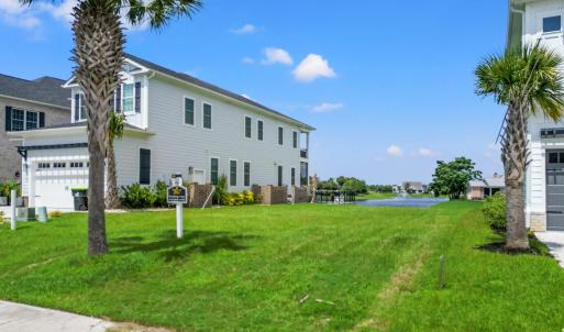 View of grassy yard featuring a water view, concre