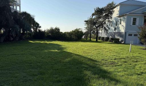 View of green lawn featuring a garage