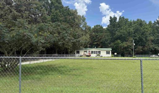 Fenced backyard featuring a forest view