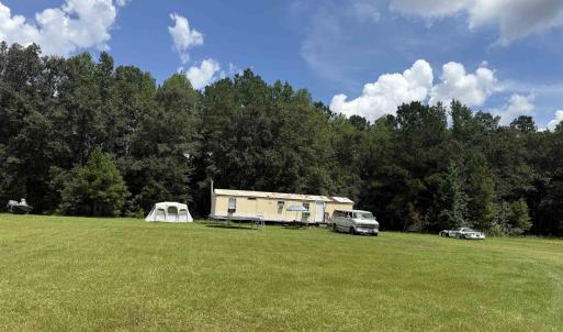 View of grassy yard featuring a view of trees