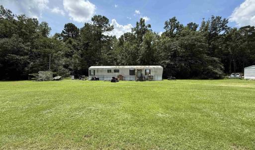 View of front facade with a front yard and a fores
