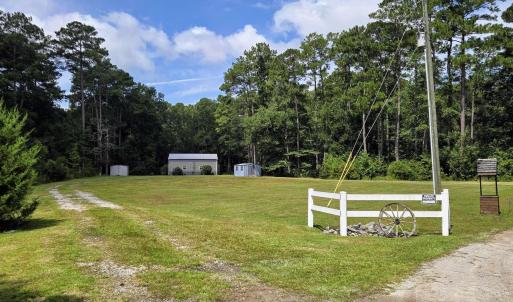 View of grassy yard featuring a wooded view and a