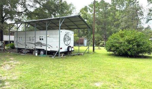 View of parking / parking lot with a carport and v