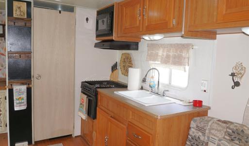 Kitchen featuring brown cabinetry, black microwave