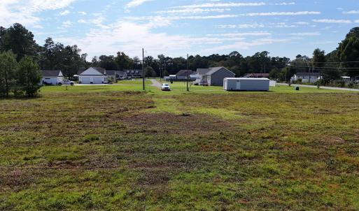 View of grassy yard featuring view of wooded area