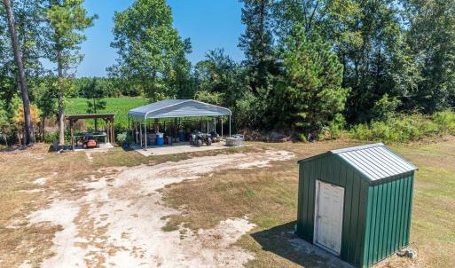 View of green lawn featuring a patio, a detached c