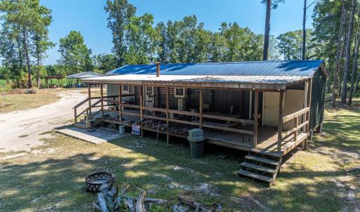 Back of property with a large porch, a yard, and a