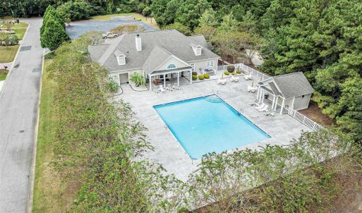 Community pool with a patio area and a wooded view