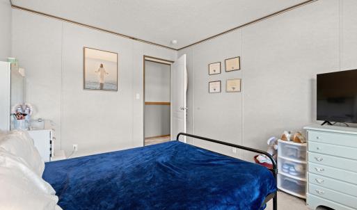 Bedroom featuring light carpet, a textured ceiling
