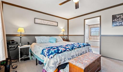 Bedroom featuring light carpet, a ceiling fan, wai