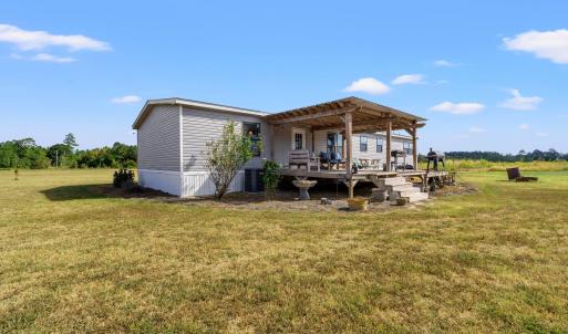 Back of property featuring a lawn and a wooden dec