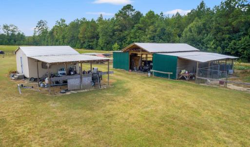 View of grassy yard with a pole building, an outbu