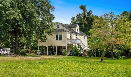 Back of house with stairway, a yard, a wooden deck