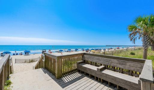 Deck with view of water and beach