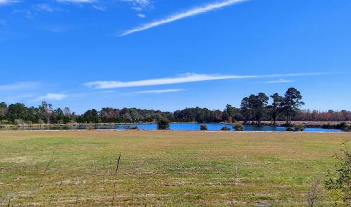View of green lawn featuring a water view and a wo