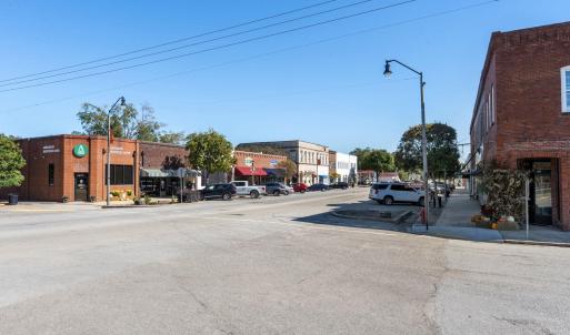 View of asphalt road with street lights, sidewalks