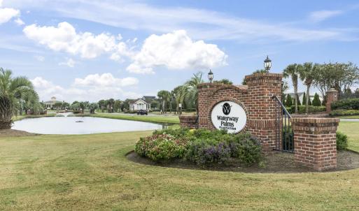 Community sign with a lawn and a water view