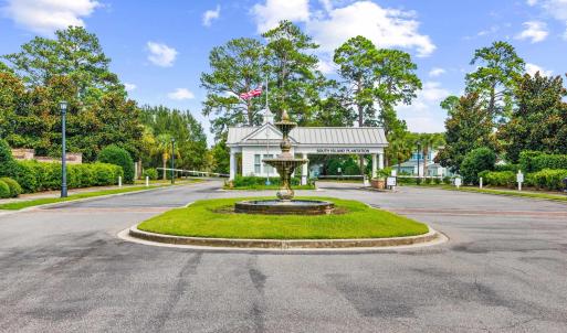 View of asphalt road featuring curbs, street light