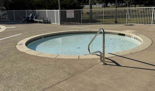 View of pool featuring a hot tub and view of scatt